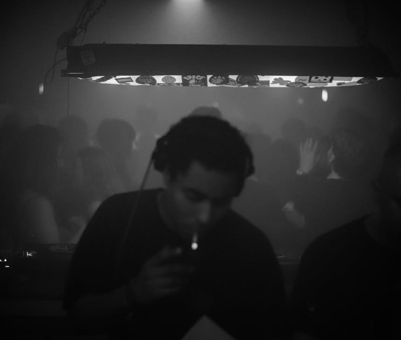 DJ playing in a hazy black and white club