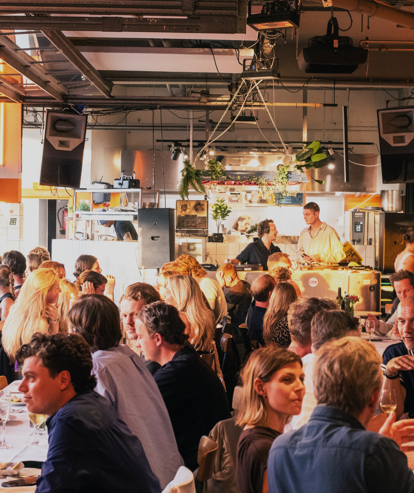 A packed Klub Analog dinner with DJs playing at the back of the room